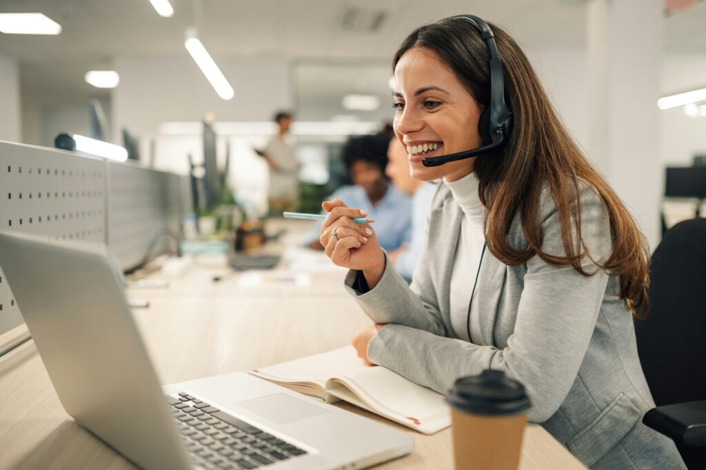 Caucasian business woman with headset working on a laptop in a call center